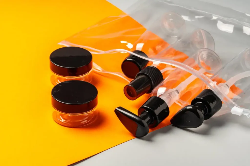 Bastidores da fabricação de embalagens plásticas para cosméticos, mostrando frascos, tampas e válvulas em uma produção industrial.