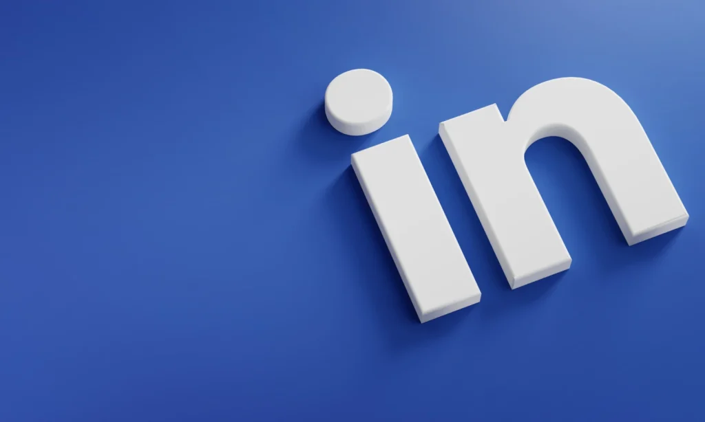 Imagem com fundo azul e o texto em 3D “IN”, com um ícone circular branco sobre o “I”, remetendo a uma ideia de entrada/inscrição e comunicação digital, ideal para ilustrar engajamento em comunidades no LinkedIn e desempenho além do feed.