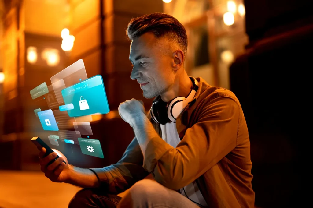 Homem em ambiente interno noturno usando smartphone e ouvindo música com fones, enquanto visual holográfico com ícones de apps aparece ao lado. O Consumidor quer IA, mas não confia nela: Como comunicar tecnologia sem soar invasivo.