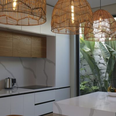 Stylish kitchen interior with big beautiful windows with a view on palms. Copy space, background.