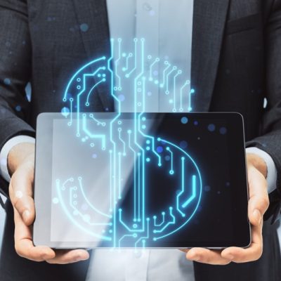 Close up of businessman hands holding pad with abstract glowing blue circuit dollar hologram on blurry bokeh office interior background. Online banking and financial technology concept. Double exposure