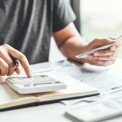 Man using calculator Accounting Calculating Cost Economic bills with money stack step growing growth saving money in home , finance concept -