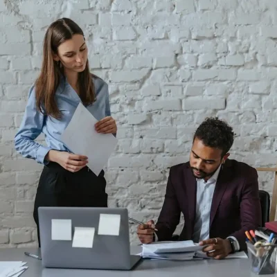 Assistente social atendendo cliente em ambiente de escritório, demonstrando empatia e profissionalismo, destacando o diferencial da profissão no setor público.