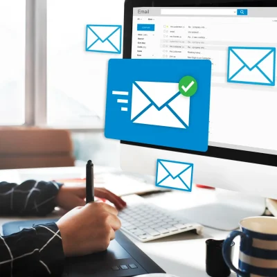 Ilustração de automação de email marketing: pessoa em escritório usando teclado e monitor com interface de e-mail, envelopes azuis e ícone de check de envio, tema de Automação de E-mail Marketing: Sequências que Ainda Convertem em 2026