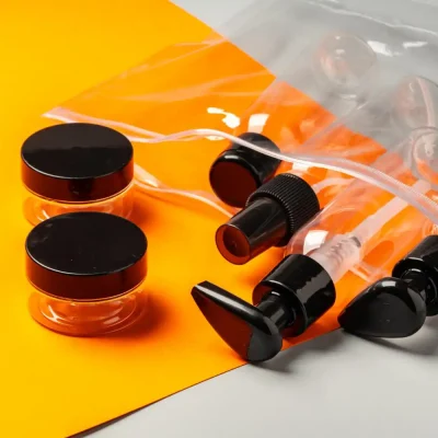 Bastidores da fabricação de embalagens plásticas para cosméticos, mostrando frascos, tampas e válvulas em uma produção industrial.