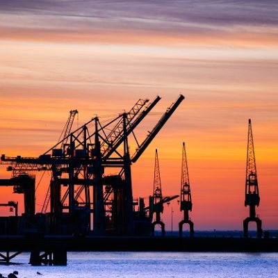 A beautiful silhouette of port machinery during sunset - Estudo proporciona segurança e inovação tecnológica ao setor energético. Foto: wirestock/ Freepik