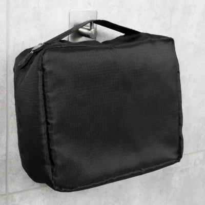 Imagem de uma bolsa térmica personalizada preta pendurada na parede, mostrando o material resistente e o design compacto.