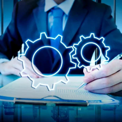 Imagem de um executivo de negócios analisando gráficos de engrenagens holográficas para decidir entre gestão de manutenção preditiva e preventiva, destacando critérios de escolha de estratégia.