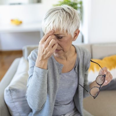 Senior woman in glasses rubs her eyes, suffering from tired eyes, ocular diseases concept Reprodução: Magnific