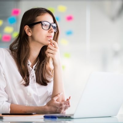 successful businesswoman working on laptop computer in her office dressed up in white strict clothes - Crédito: Freepik