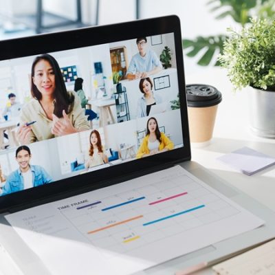 Young Asia businesswoman using laptop talk to colleague about plan in video call meeting while work from home at living room. Self-isolation, social distancing, quarantine for corona virus prevention.